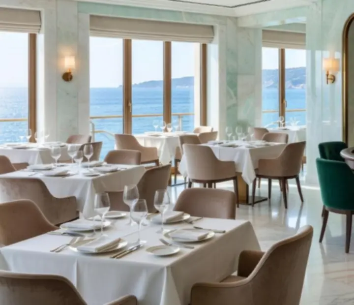 Salle lumineuse de restaurant gastronomique reliée à un salon casino privé avec roulette et tables de cartes.